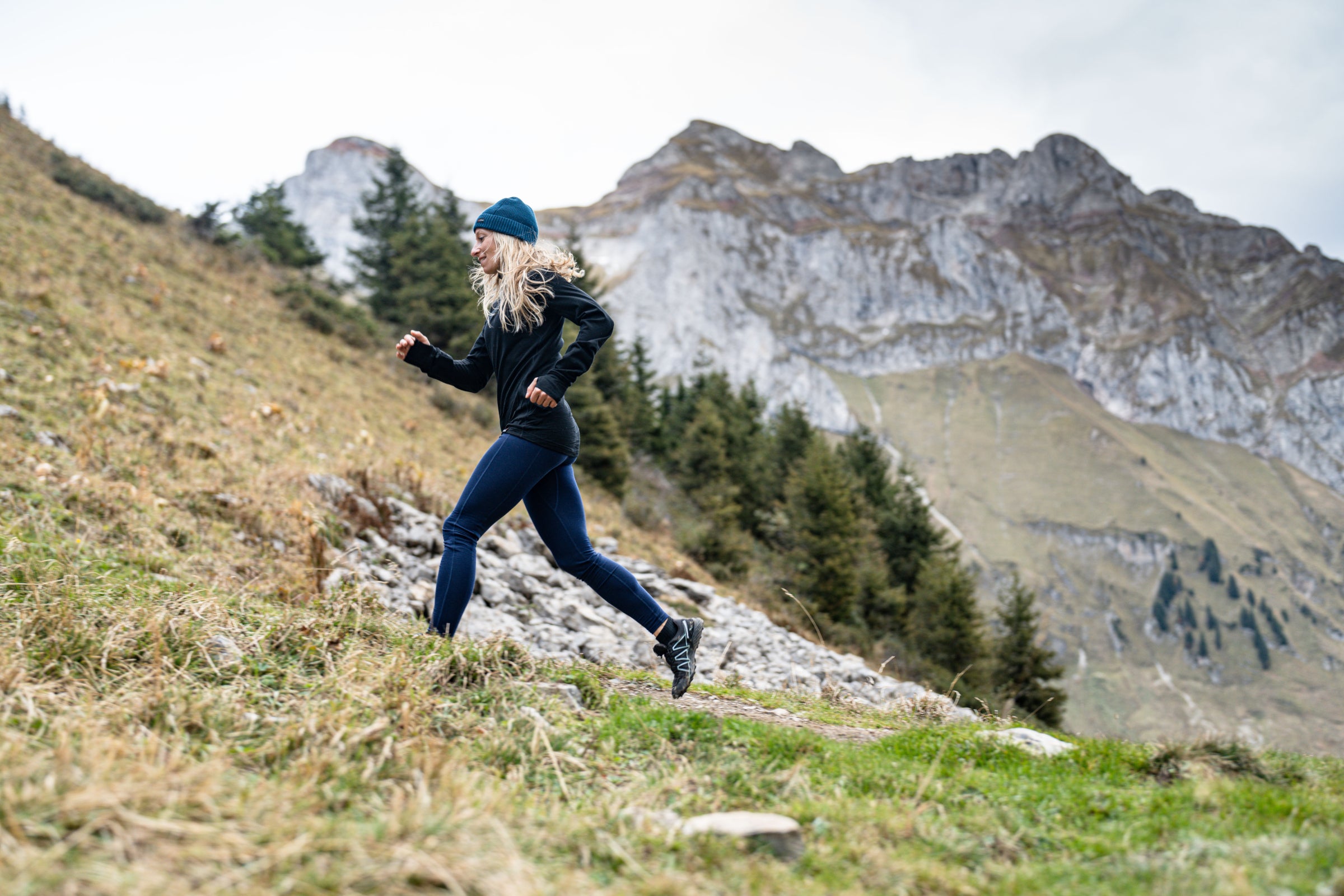 Runner in black top ascending rocky terrain
