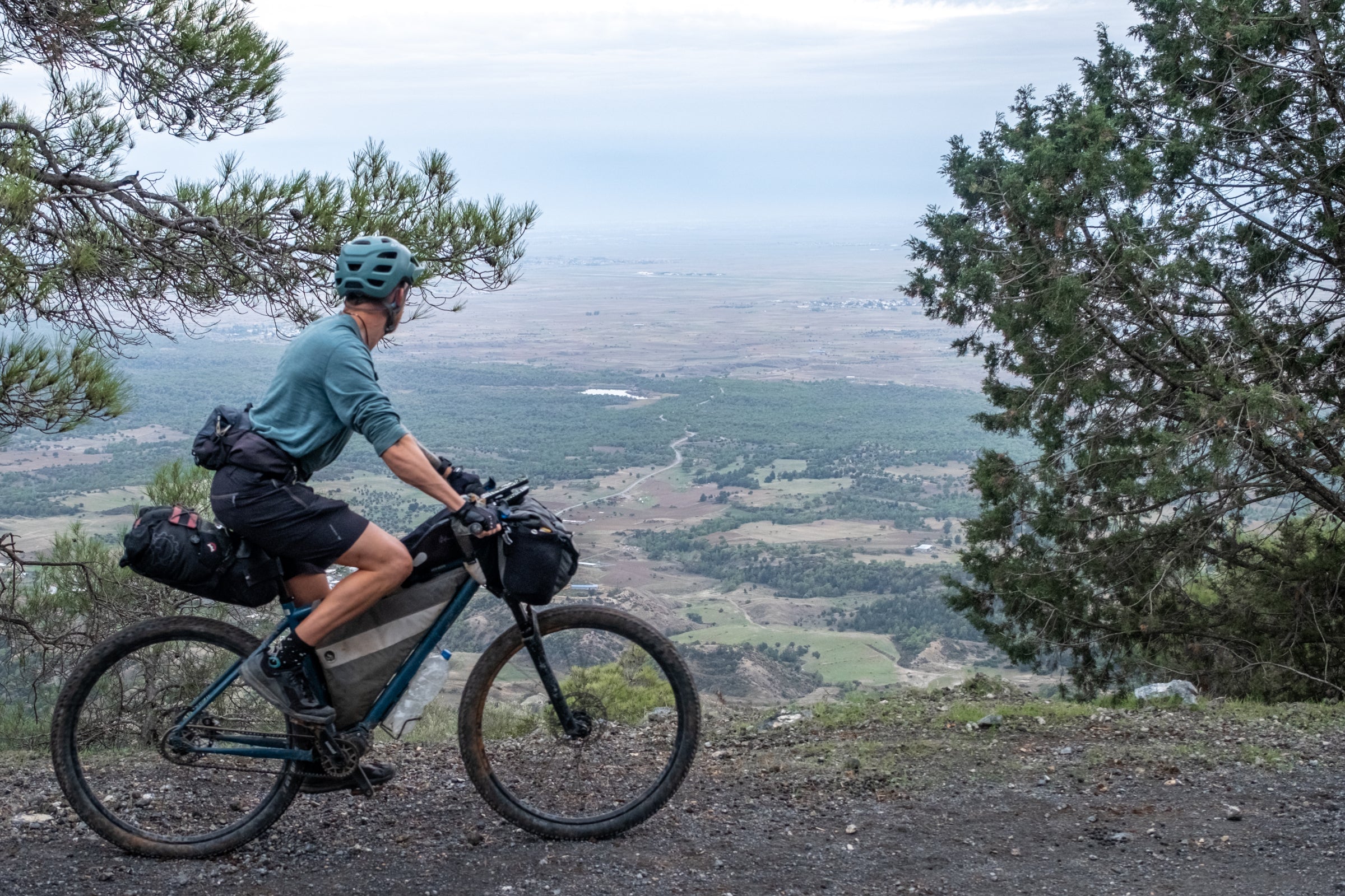 Bikepacking cyclist wearing Isobaa merino overlooking a valley