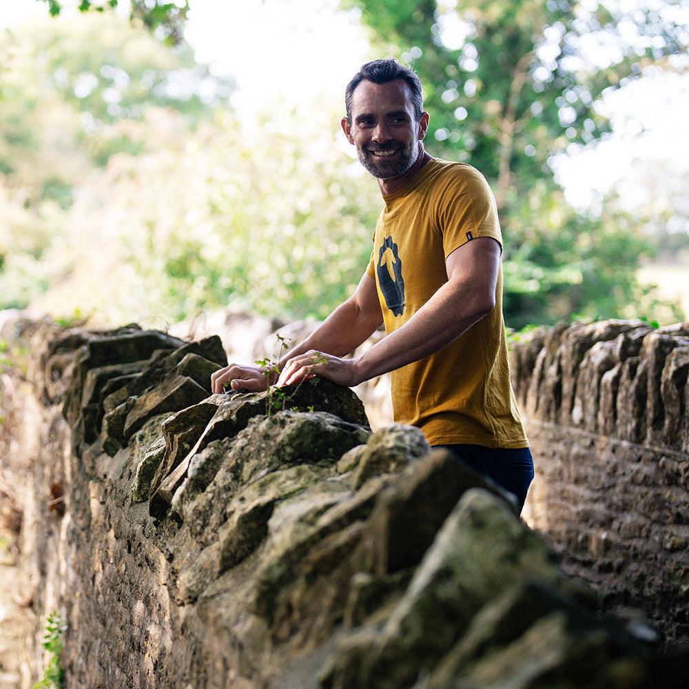 Isobaa | Mens Merino 150 Emblem Tee (Mustard/Navy) | Conquer trails and city streets in comfort with Isobaa's superfine Merino T-Shirt. | Model: Ben