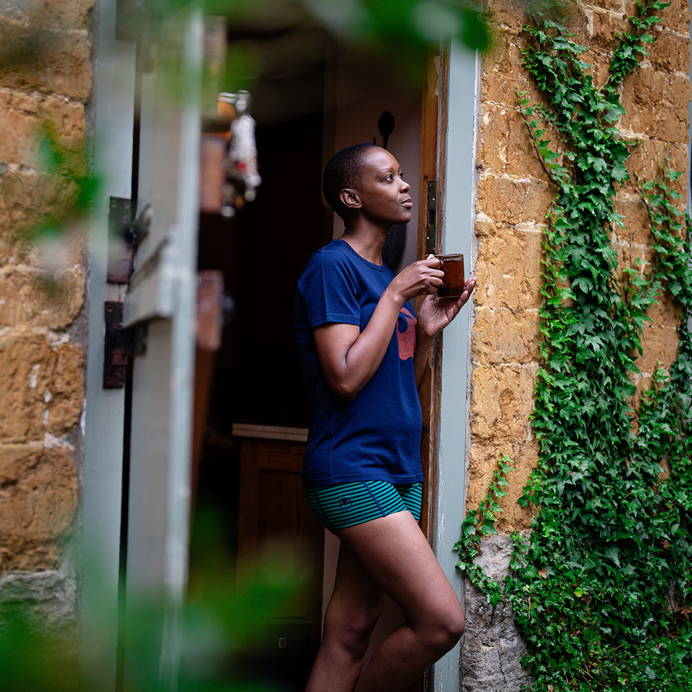 Isobaa | Womens Merino 150 Emblem Tee (Navy/Orange) | Conquer trails and city streets in comfort with Isobaa's superfine Merino T-Shirt. | Model: Yolisa