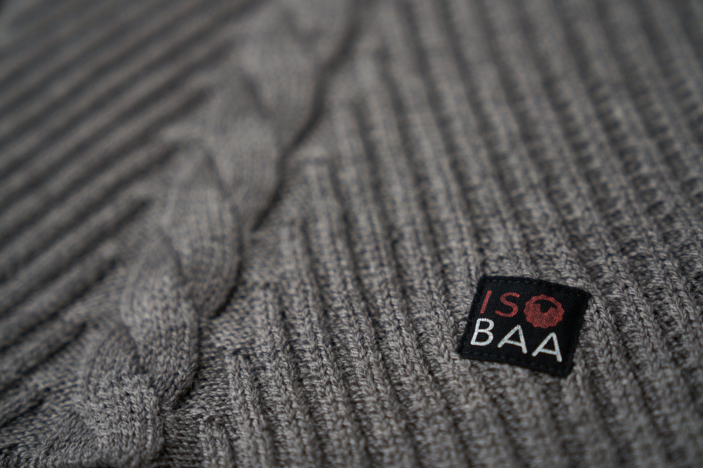 Close-up of a grey knit fabric with an Isobaa logo label