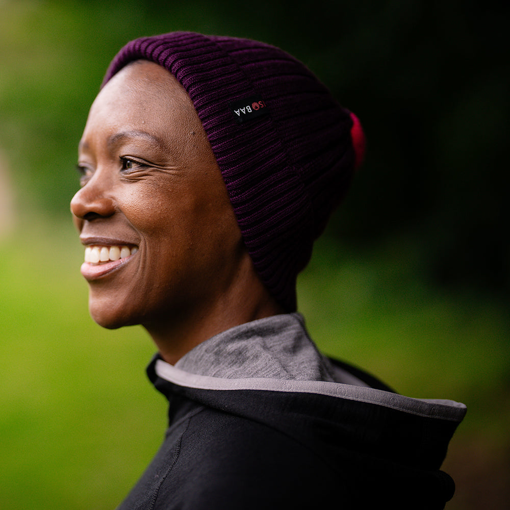 Isobaa | Merino Bobble Beanie (Wine/Fuchsia) | Stay warm and stylish with Isobaa's extra-fine Merino bobble beanie! Its cosy warmth, playful bobble, and classic rib-knit design will make it your go-to winter essential for hikes, city strolls, and everything in between.