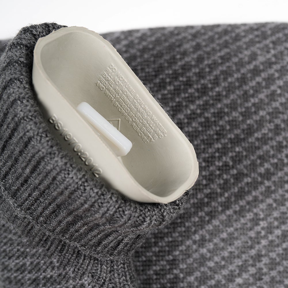 Isobaa | Merino Jacquard Hot Water Bottle Cover (Charcoal/Smoke) | Say goodbye to ordinary hot water bottles! You'll love the luxurious feel of our Merino wool cover – and your skin will thank you! Wrap yourself in cosy warmth, enjoy natural breathability, and discover the ultimate hot water bottle indulgence.