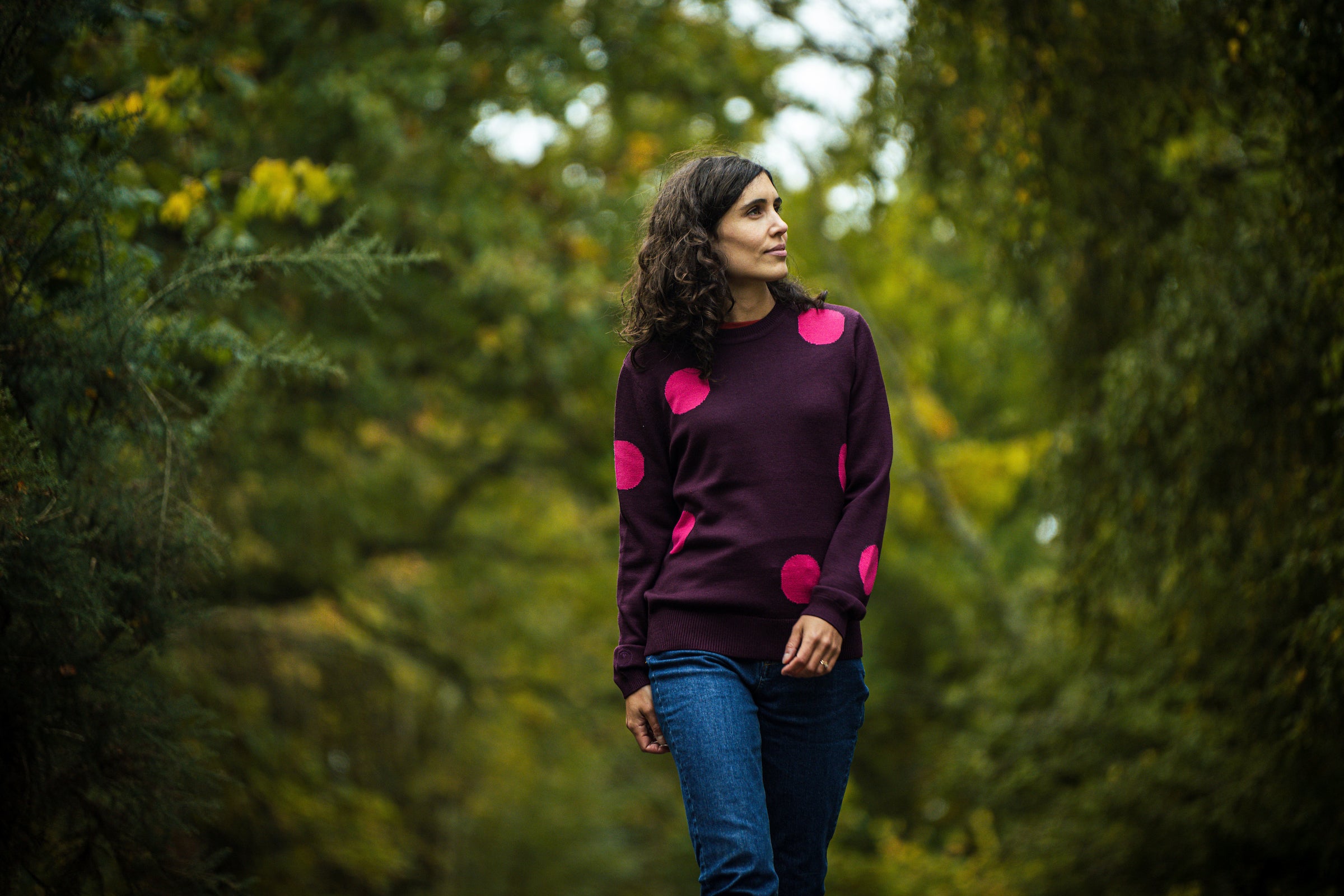 A person wearing an Isobaa Merino polka dot sweater while walking outdoors