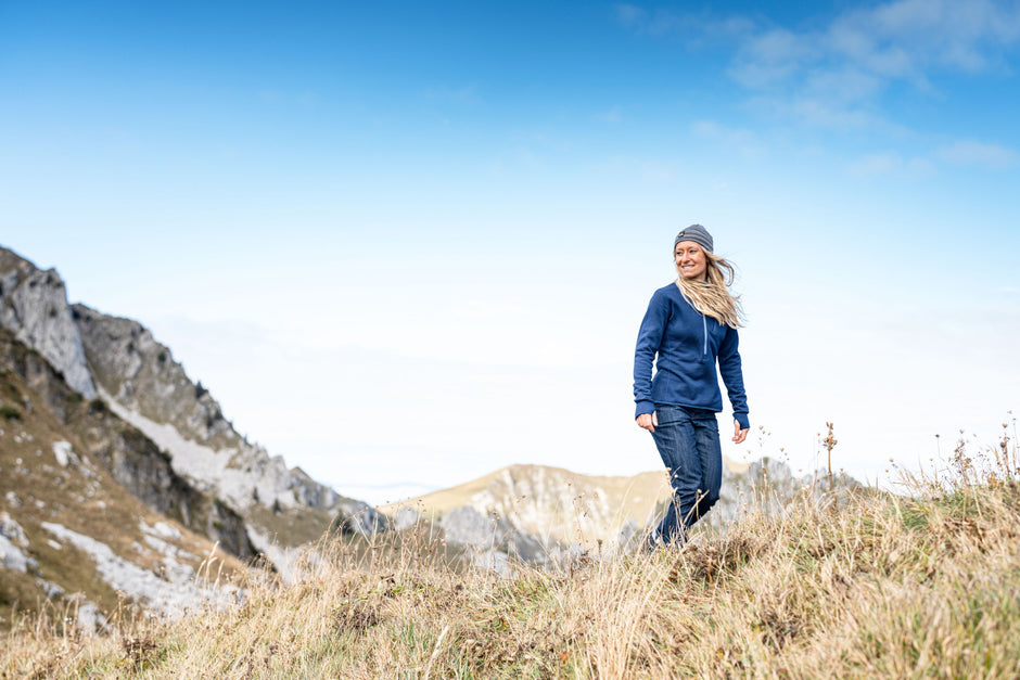 A woman in a merino fleece on a mountain