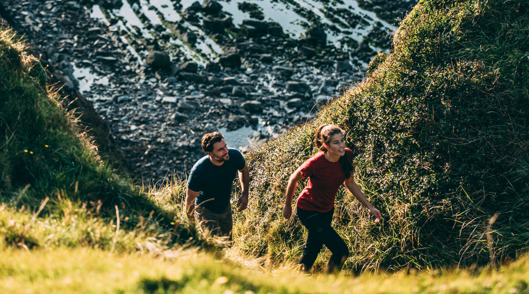 Isobaa Merino 150 Short Sleeve Crew climbing a grassy hillside