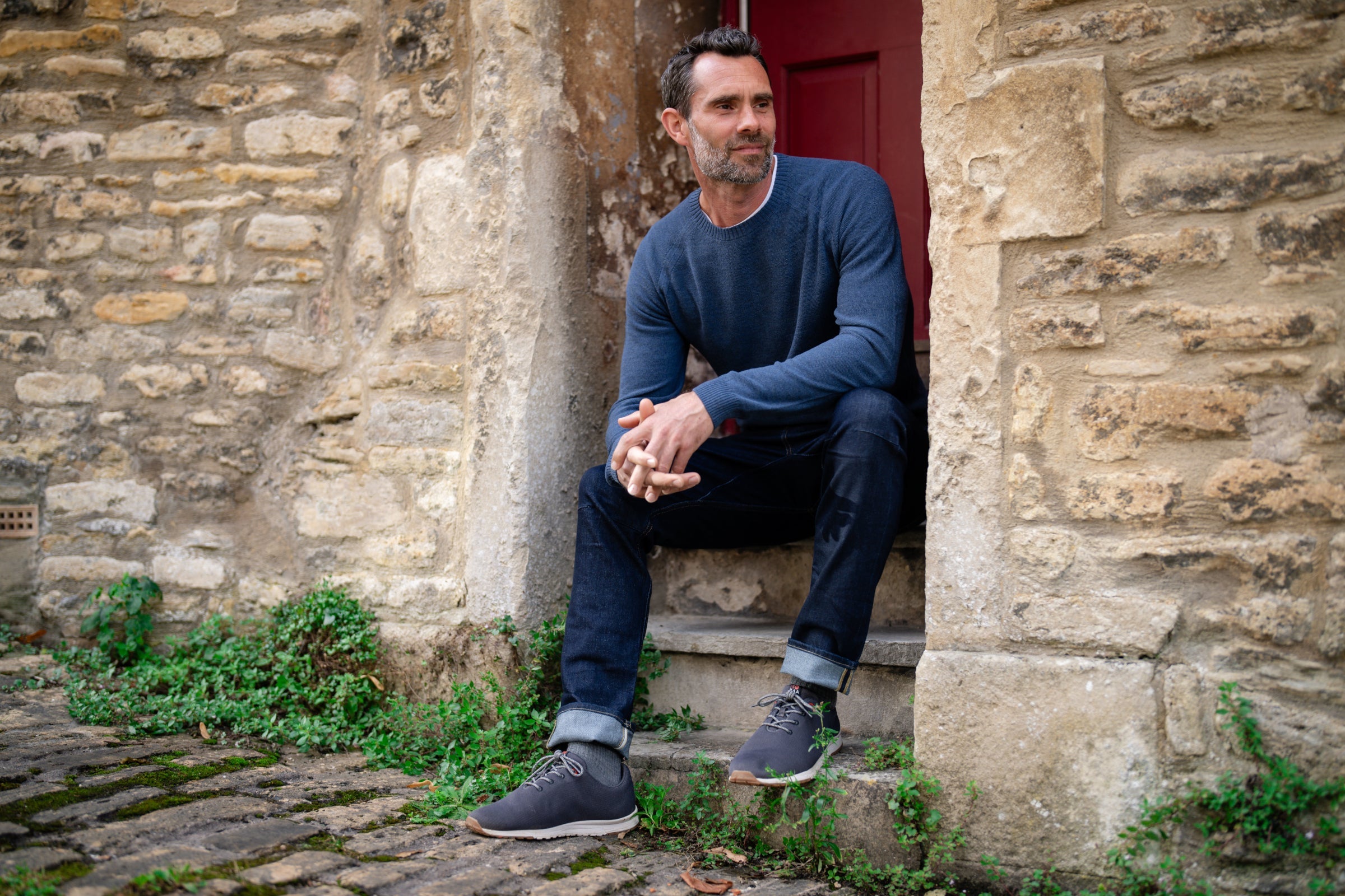 Man sitting on stone steps outside a building