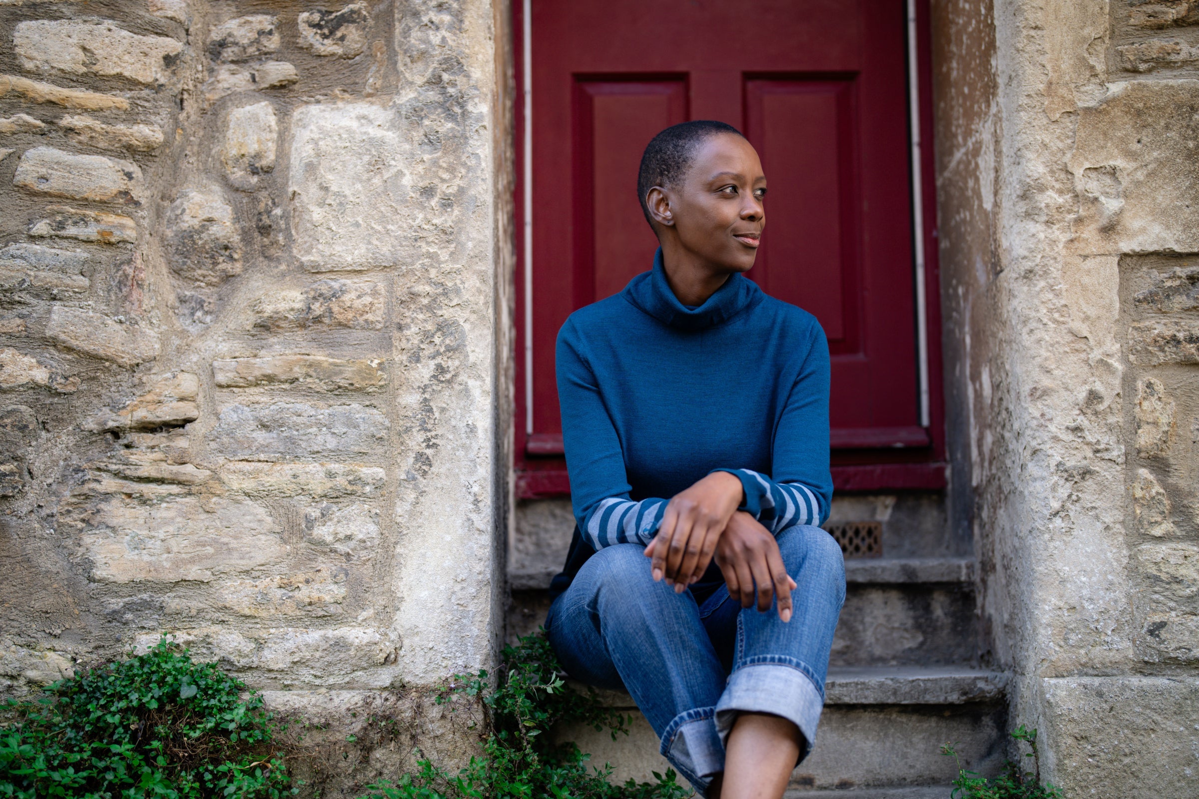 Woman sitting on stone steps outside a building