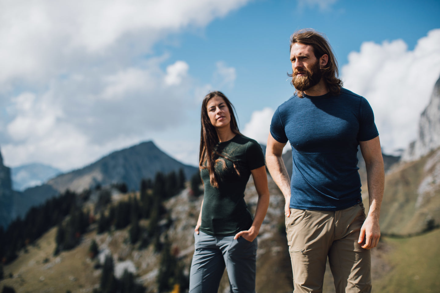 Man and woman standing in a mountain landscape, both wearing fitted Isobaa merino t-shirts