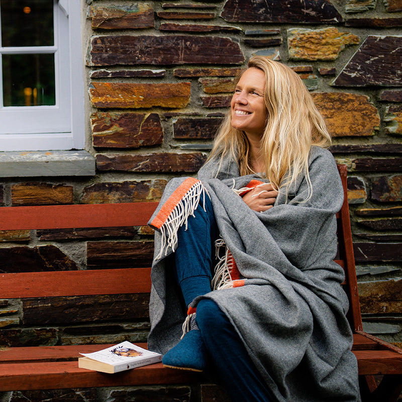 Isobaa | Merino-Überwurf mit Fischgrätenmuster (Anthrazit/Orange gestreift) | Hüllen Sie sich in puren Komfort mit dem superweichen Merino-Überwurf von Isobaa.