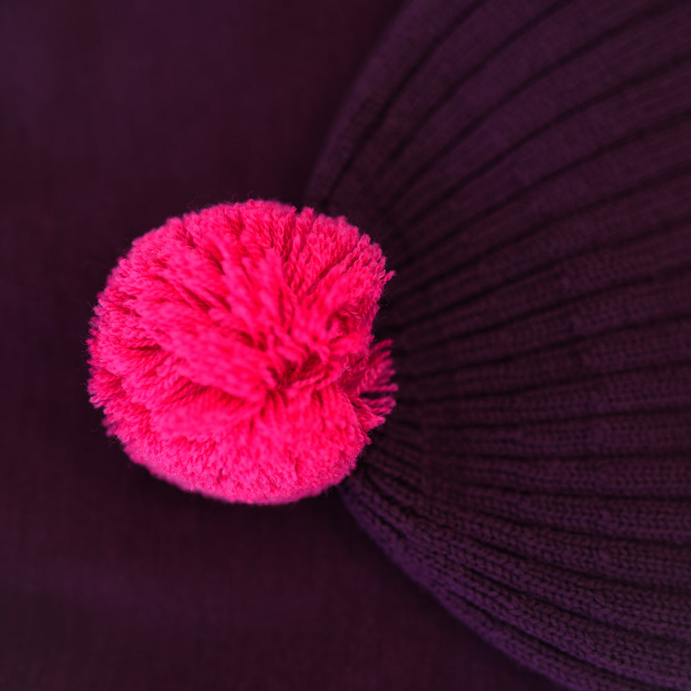 Isobaa | Merino Bobble Beanie (Wine/Fuchsia) | Stay warm and stylish with Isobaa's extra-fine Merino bobble beanie! Its cosy warmth, playful bobble, and classic rib-knit design will make it your go-to winter essential for hikes, city strolls, and everything in between.